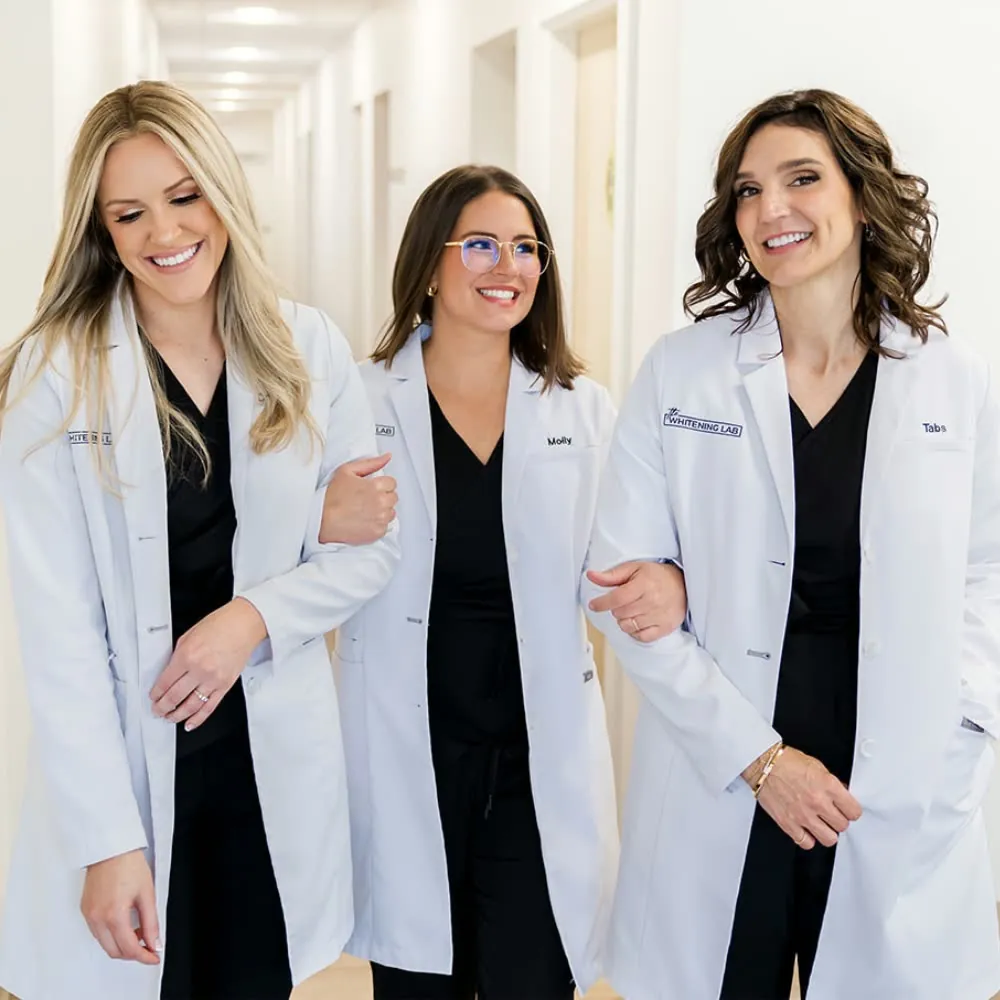The Whitening Lab clinical team — three licensed / certified dental professionals in black scrubs