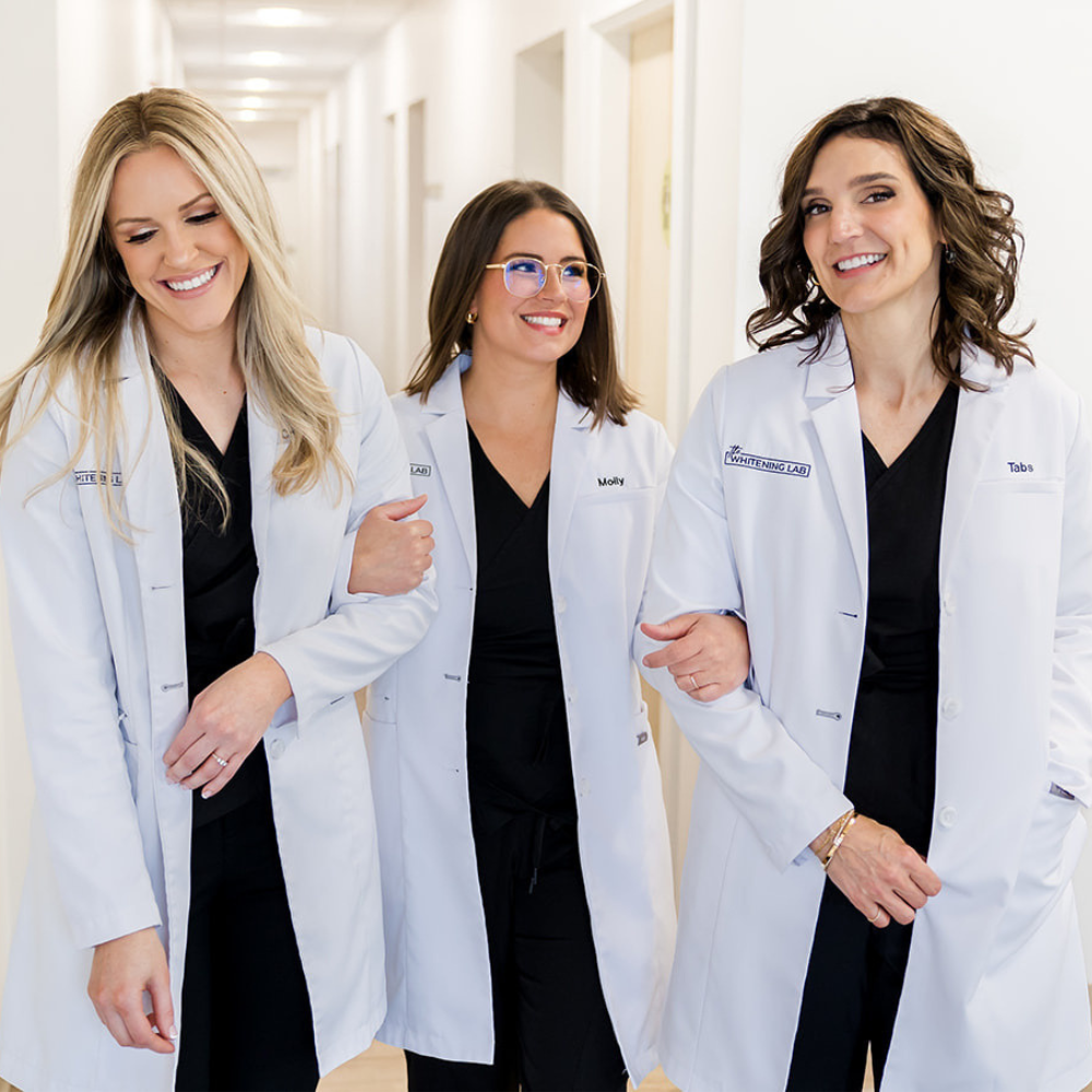 The The Whitening Lab clinical team — three licensed dental professionals in black scrubs